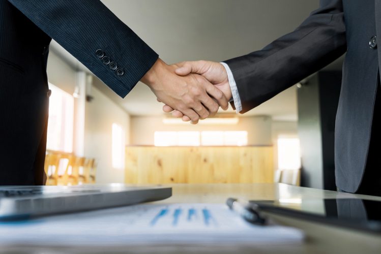 Two confident business man shaking hands during a meeting in the office, success, dealing, greeting and partner concept